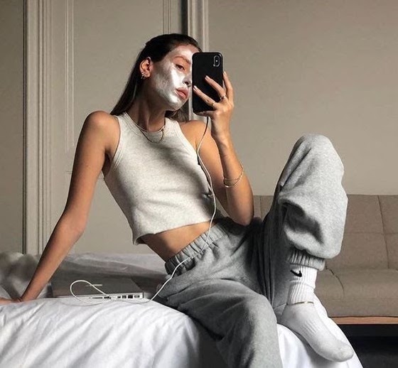 Girl poses in a face mask and sweatpants